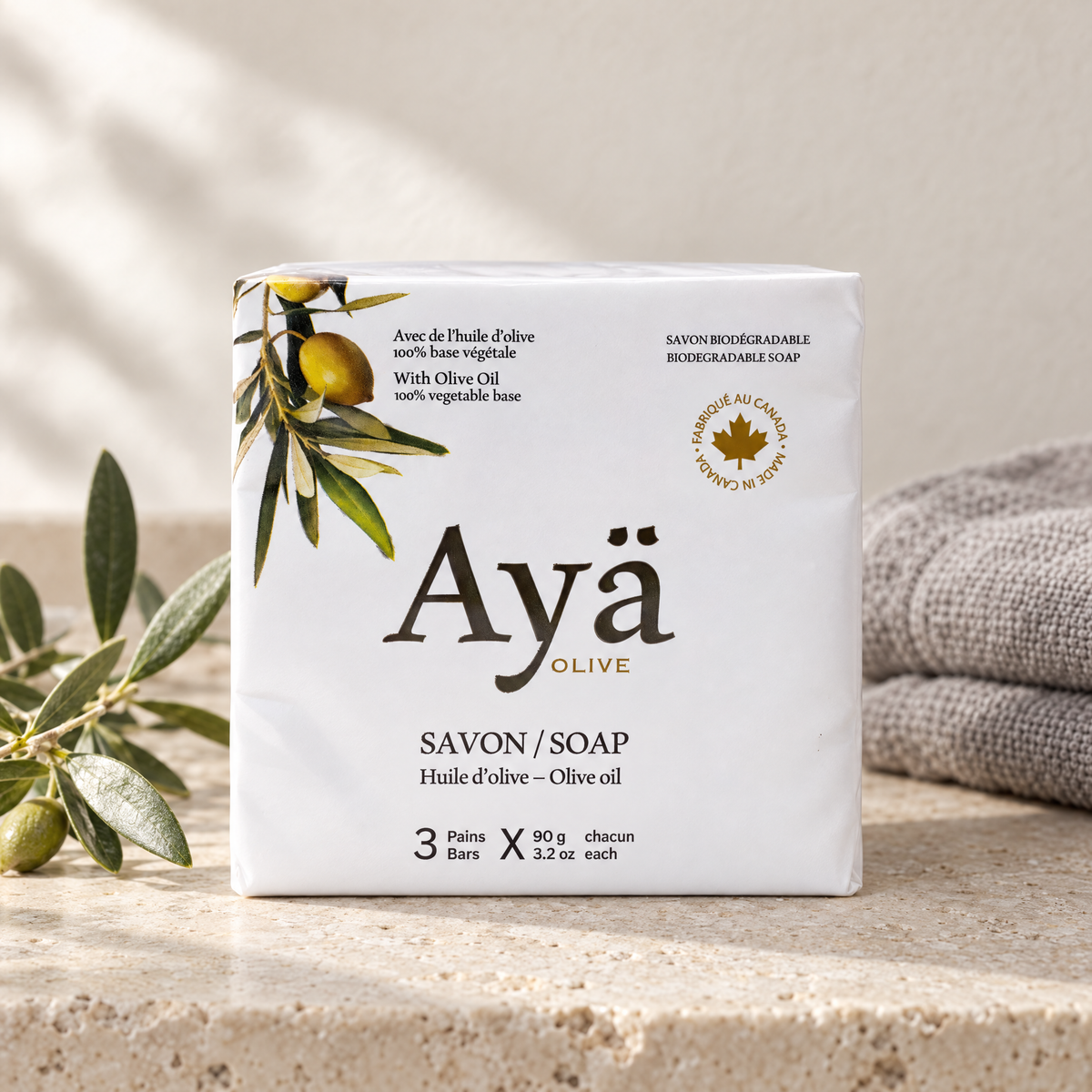 Ayä Olive bar soap 3x90g pack on a limestone washstand with linen towel and olive sprig