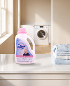 Brillex Baby Gentle Care laundry detergent 1,9L jug on a laundry room countertop beside folded baby clothes