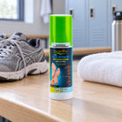 Novarnica foot pain relief spray 65 ml on a gym locker room bench with running shoes and a towel